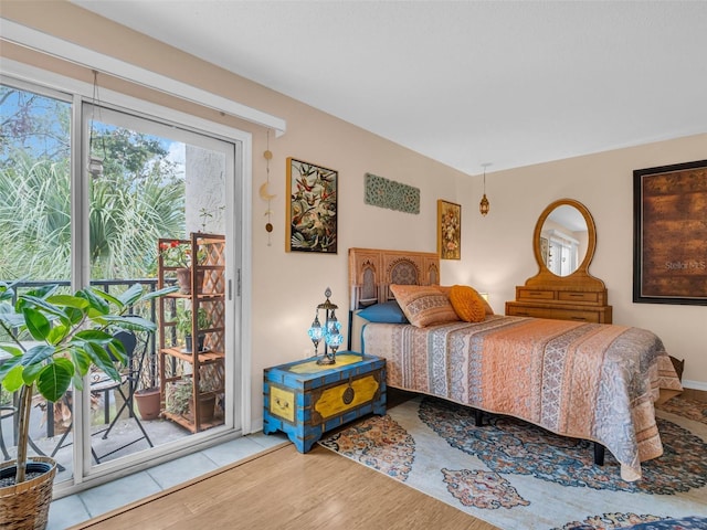 bedroom with access to outside and wood finished floors