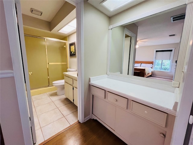 bathroom featuring vanity, toilet, hardwood / wood-style floors, and walk in shower