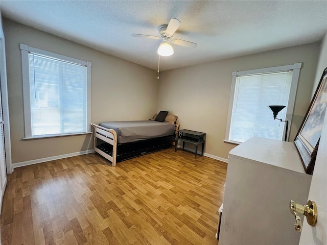 bedroom featuring a textured ceiling, light hardwood / wood-style flooring, and ceiling fan