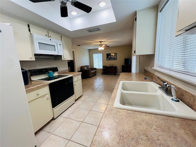 kitchen with sink, light tile patterned floors, white cabinets, and white appliances