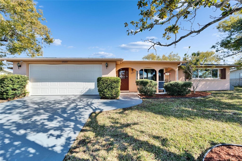 single story home featuring a garage and a front lawn