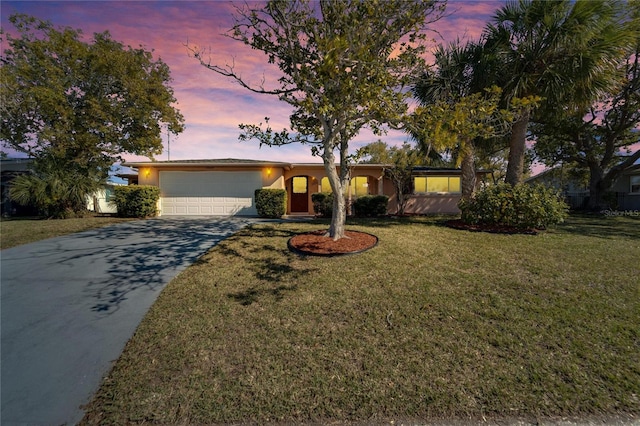 ranch-style home with a garage and a yard