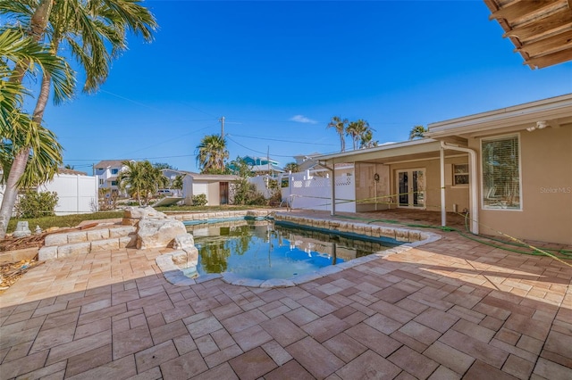 view of swimming pool with a patio area and a storage unit