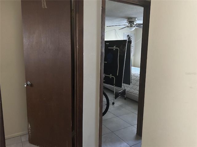 hallway with light tile patterned floors and a textured ceiling