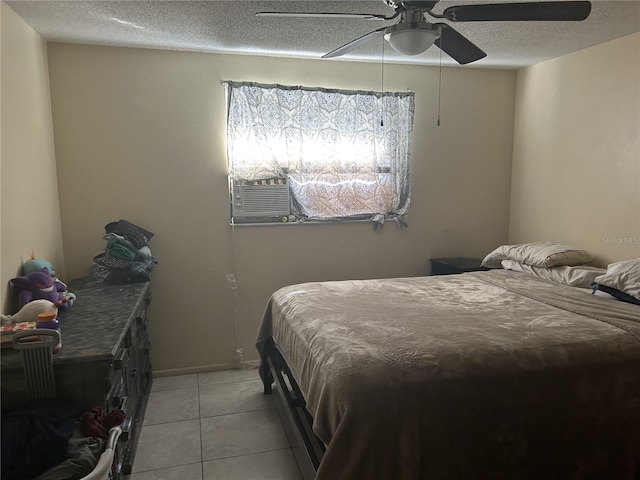 tiled bedroom featuring cooling unit, a textured ceiling, and ceiling fan