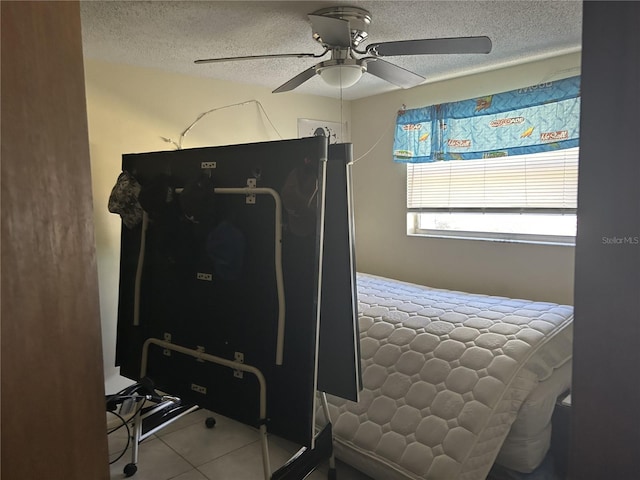 bedroom featuring tile patterned flooring, a textured ceiling, and ceiling fan