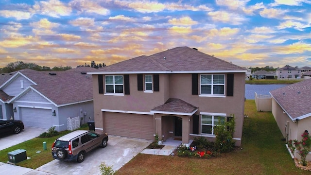 front of property featuring a garage and a lawn