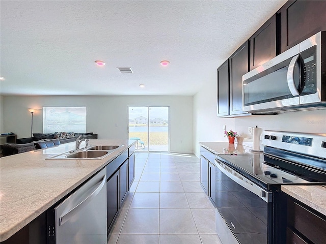 kitchen featuring light tile patterned flooring, stainless steel appliances, sink, and plenty of natural light