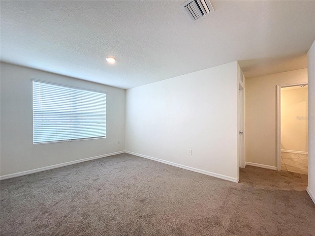 unfurnished room featuring a textured ceiling and carpet flooring