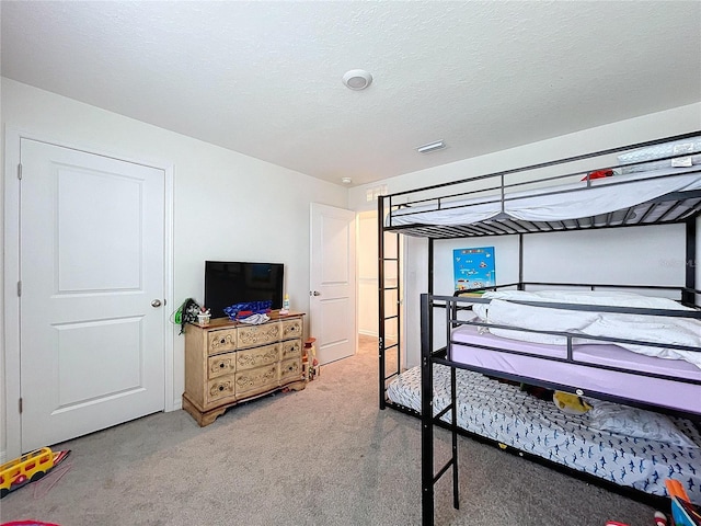 carpeted bedroom featuring a textured ceiling