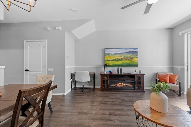 living room featuring dark wood-type flooring and ceiling fan with notable chandelier