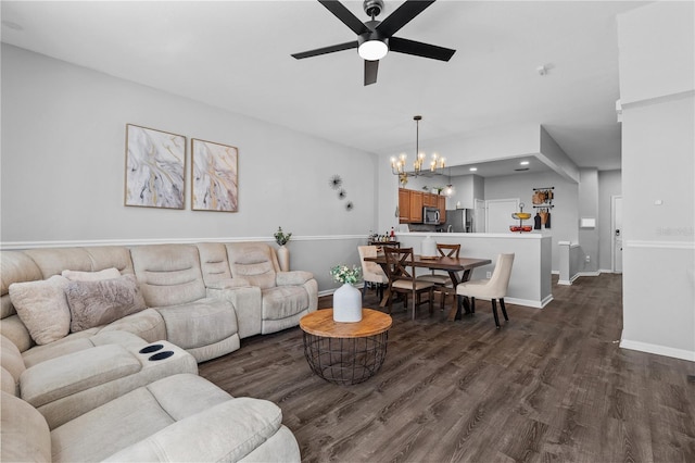 living room featuring ceiling fan with notable chandelier and dark hardwood / wood-style floors