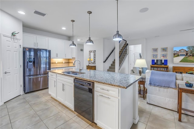 kitchen with an island with sink, black dishwasher, sink, white cabinets, and stainless steel fridge with ice dispenser