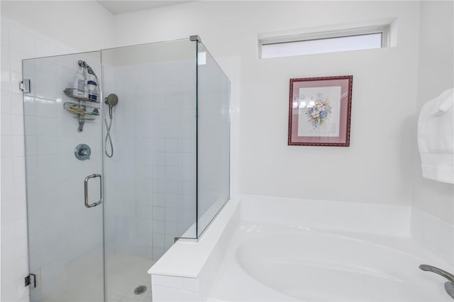 bathroom featuring shower with separate bathtub