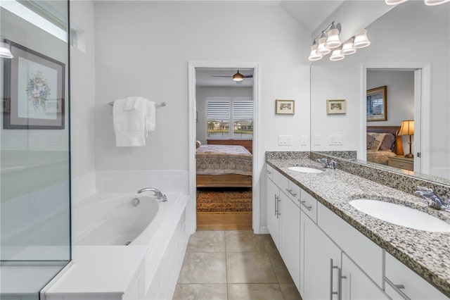 bathroom featuring lofted ceiling, vanity, tile patterned floors, and tiled tub