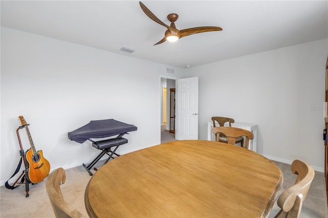 carpeted dining space with ceiling fan