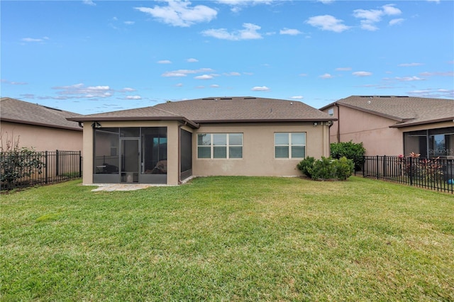 back of property with a sunroom and a yard