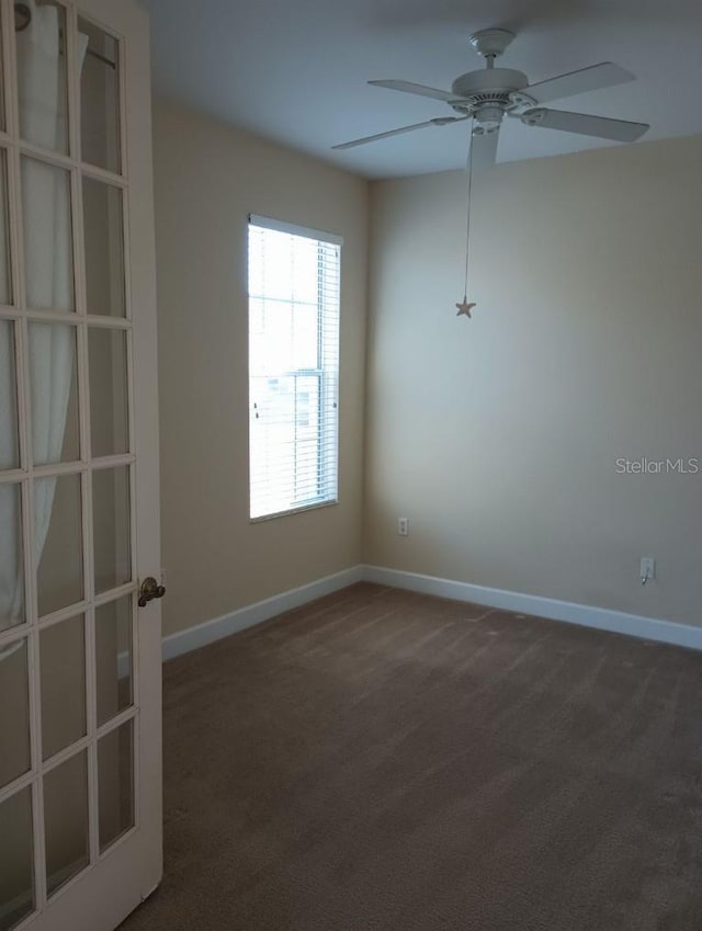 carpeted spare room with ceiling fan