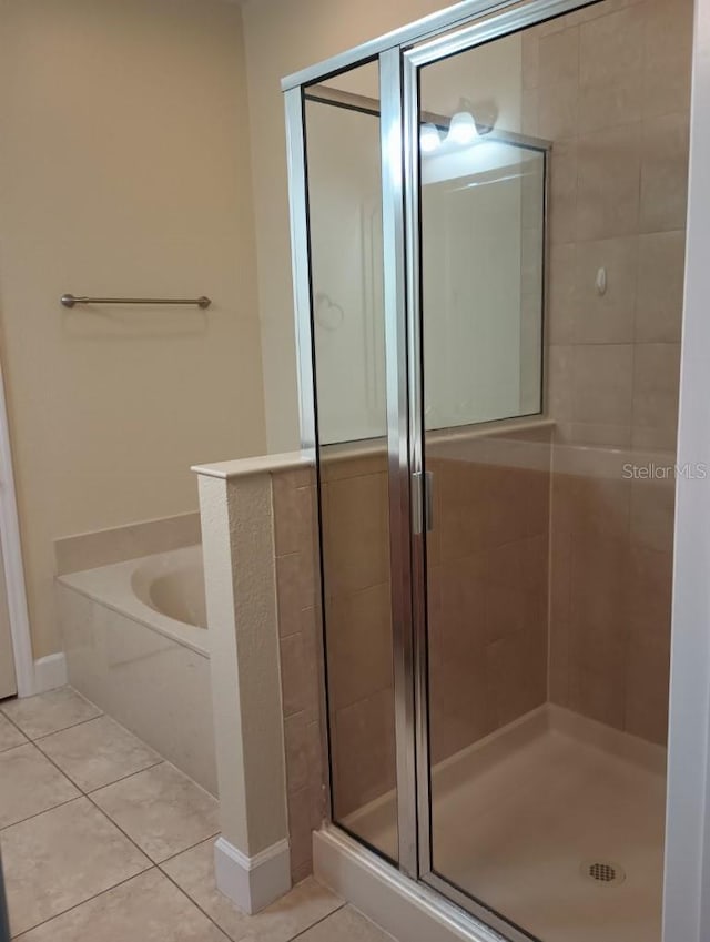 bathroom with tile patterned flooring and separate shower and tub