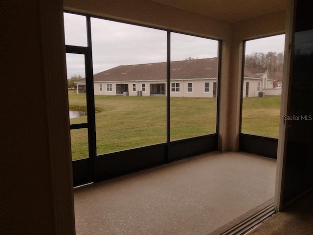 unfurnished sunroom featuring a water view