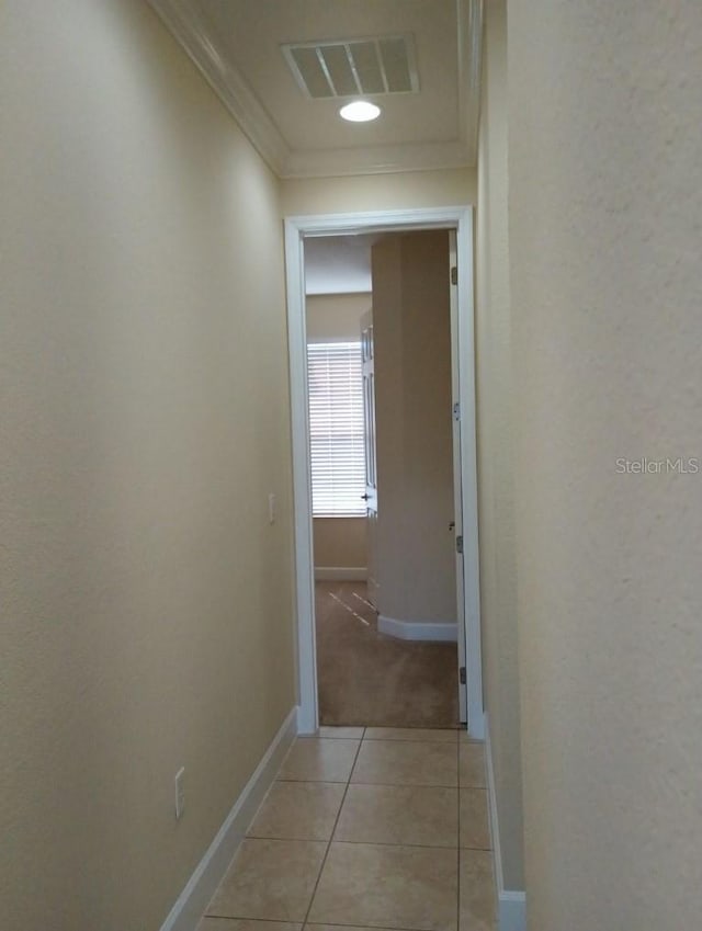 hallway with light tile patterned flooring and crown molding