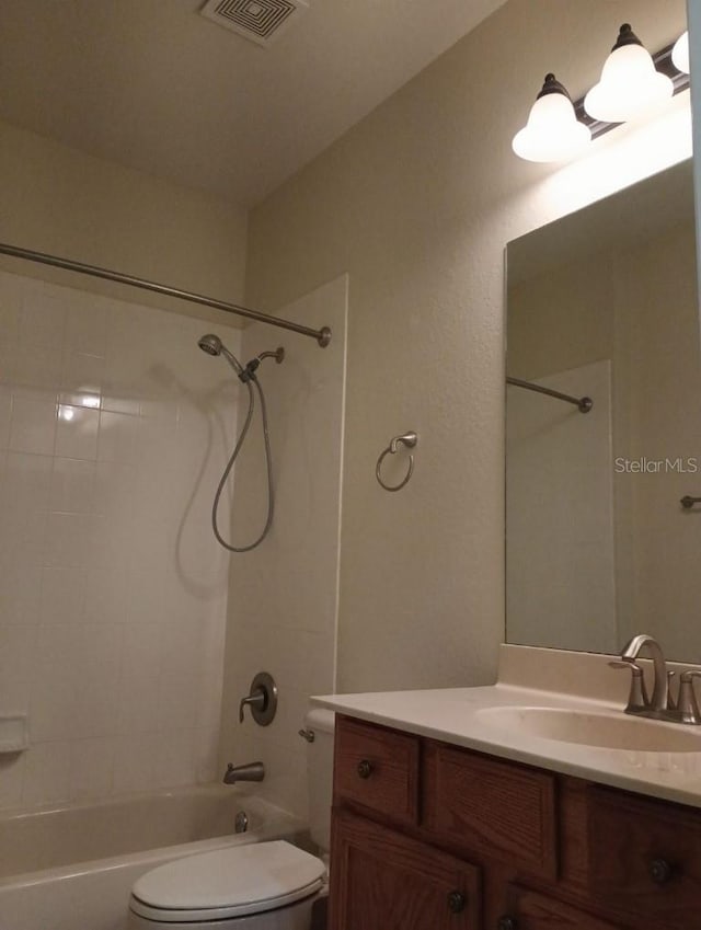 full bathroom featuring tiled shower / bath combo, vanity, and toilet