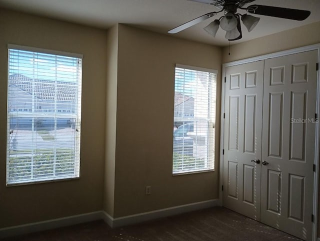 unfurnished bedroom featuring dark hardwood / wood-style flooring, ceiling fan, and a closet