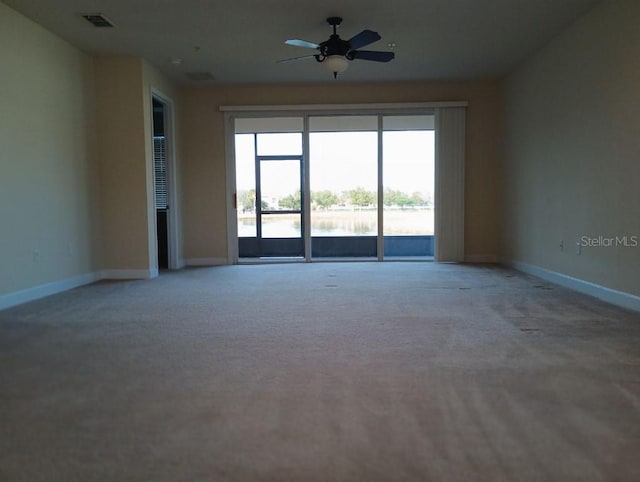 empty room featuring carpet floors and ceiling fan