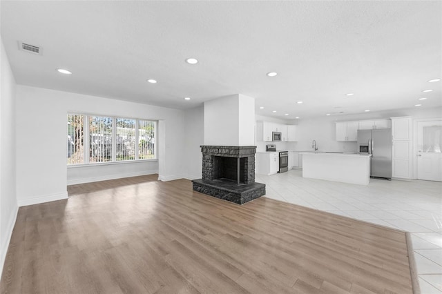 unfurnished living room featuring a fireplace and light tile patterned floors