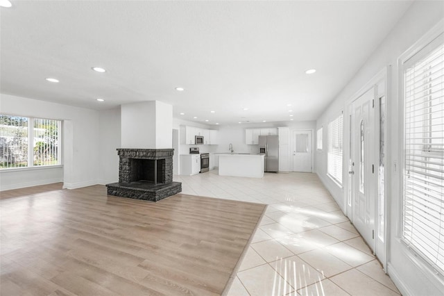 tiled living room featuring sink and a fireplace