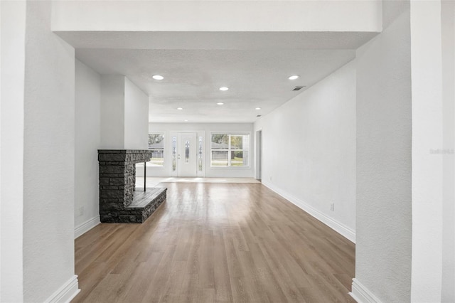 unfurnished living room with a fireplace and light wood-type flooring