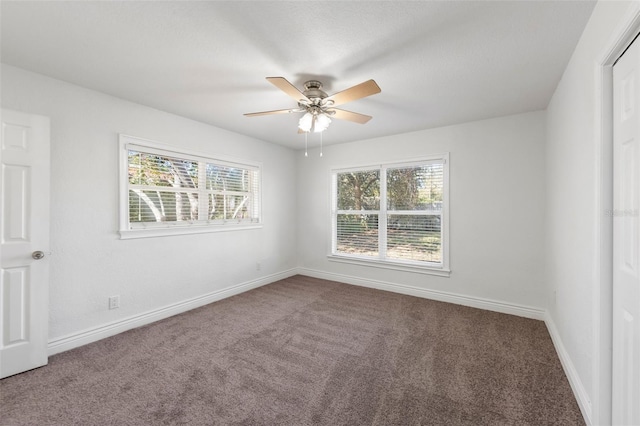 carpeted spare room featuring ceiling fan