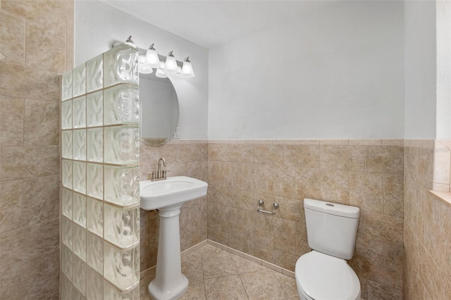 bathroom featuring tile walls, tile patterned floors, and toilet