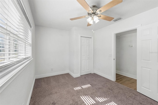 unfurnished bedroom featuring carpet, ceiling fan, and a closet