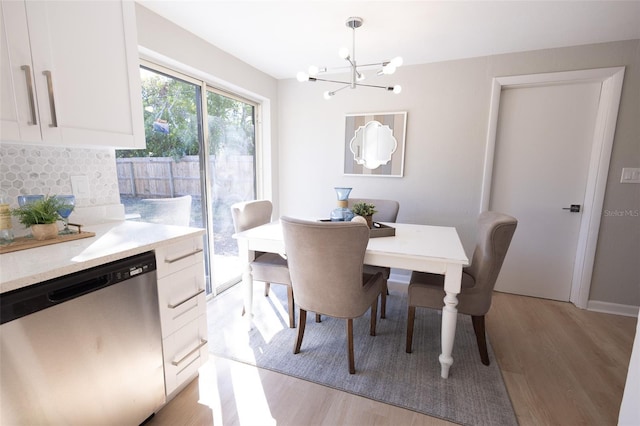 dining space with a notable chandelier and light hardwood / wood-style flooring