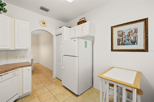 kitchen with white cabinetry, white appliances, decorative backsplash, and light tile patterned floors