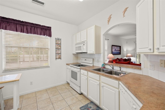 kitchen featuring tasteful backsplash, sink, white appliances, and white cabinets