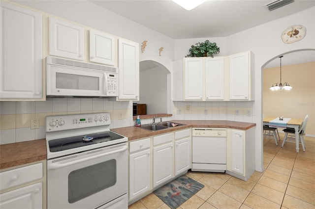 kitchen with light tile patterned flooring, sink, decorative light fixtures, white appliances, and white cabinets