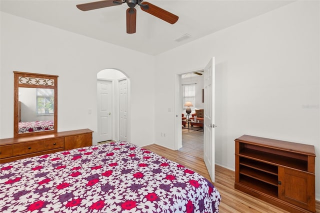 bedroom with multiple windows, ceiling fan, and light hardwood / wood-style floors