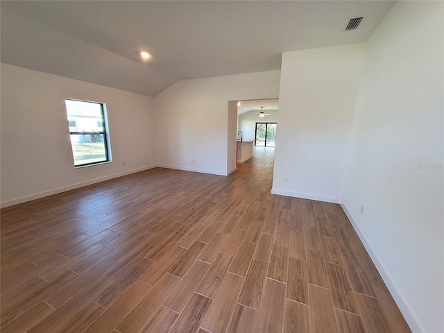 unfurnished room featuring hardwood / wood-style flooring and vaulted ceiling