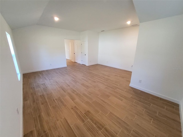 unfurnished room with light hardwood / wood-style floors and vaulted ceiling