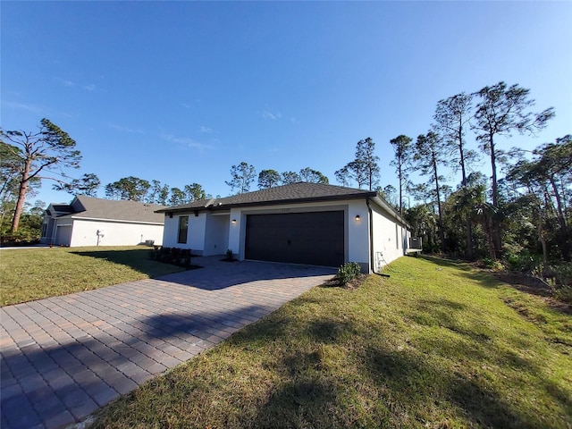 ranch-style home featuring a front lawn, decorative driveway, an attached garage, and stucco siding