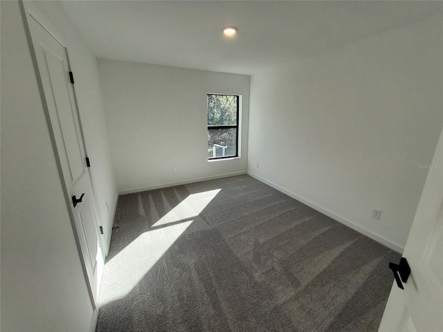 bedroom featuring dark colored carpet and baseboards