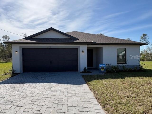 single story home with a garage and a front yard