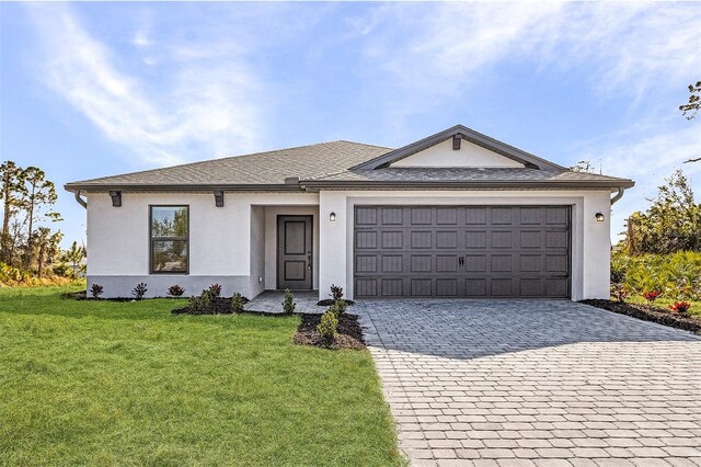 3560 Bellefonte Ave, North Port, FL 34286 - ranch-style house with roof with shingles, stucco siding, a front lawn, decorative driveway, and a garage