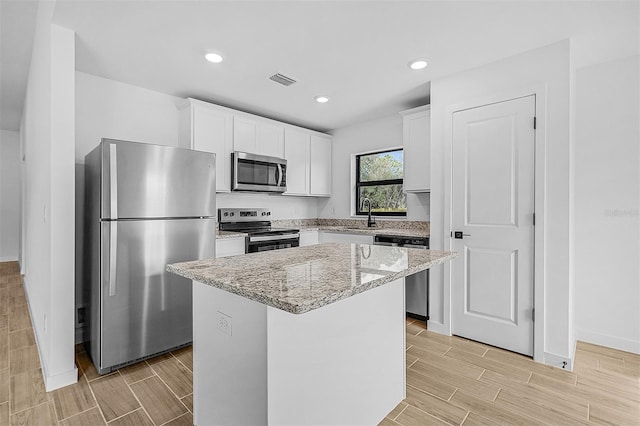 3560 Bellefonte Ave, North Port, FL 34286 - kitchen with a center island, wood tiled floor, visible vents, and appliances with stainless steel finishes