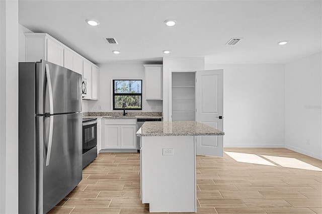 3560 Bellefonte Ave, North Port, FL 34286 - kitchen featuring a kitchen island, a sink, visible vents, appliances with stainless steel finishes, and wood tiled floor