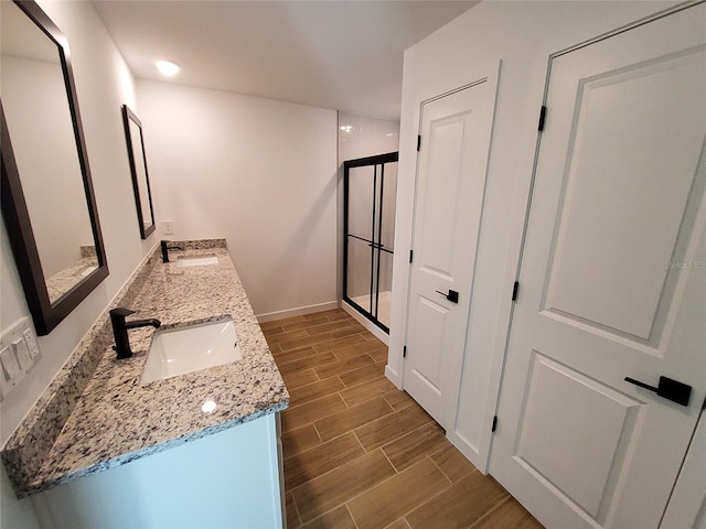 bathroom with vanity and a shower with door