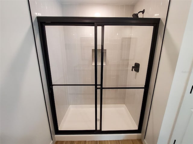 bathroom with an enclosed shower and hardwood / wood-style floors