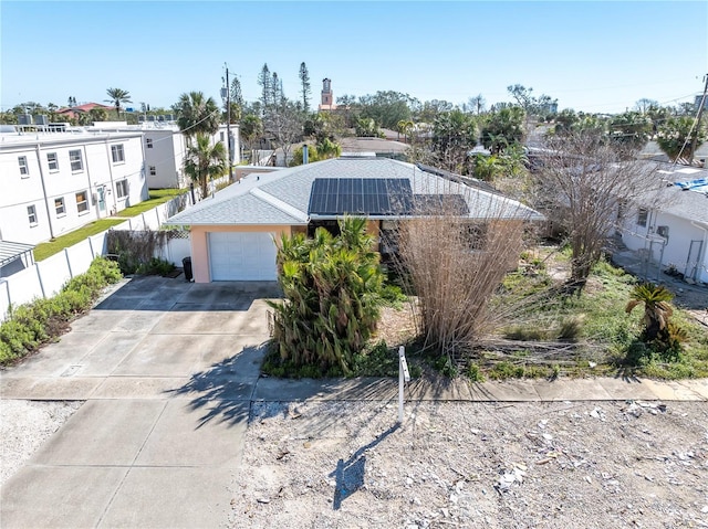 view of front of property with a garage and solar panels